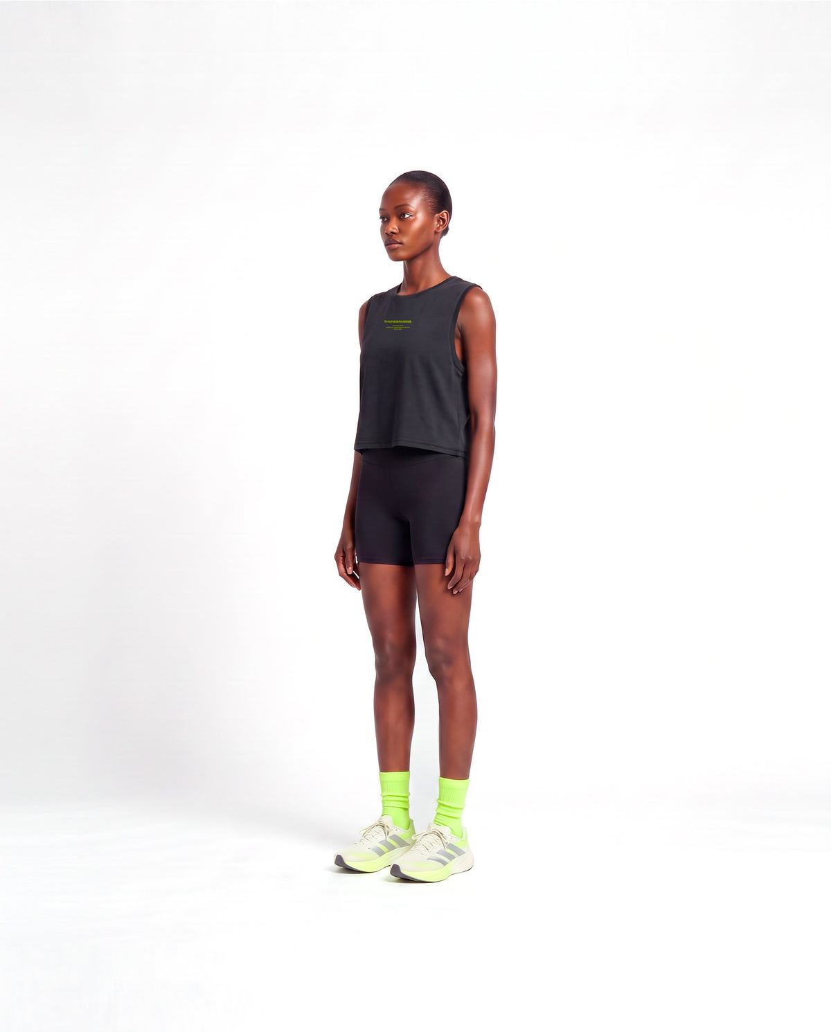 Model wearing the Brick by Brick cropped tank top in black — three-quarter view showing the cropped fit — Vista 3