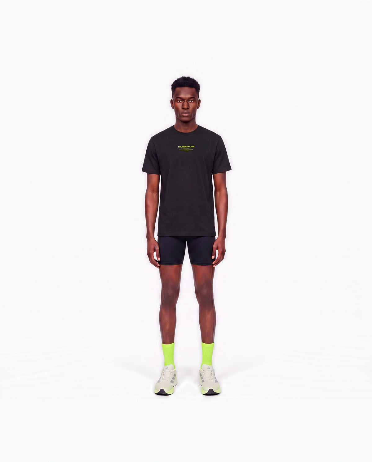 Model wearing the Brick by Brick t-shirt in black — front view with the THUNDERNOISE TRAINING DEPT block centred on the chest in lime green — Ansicht 2