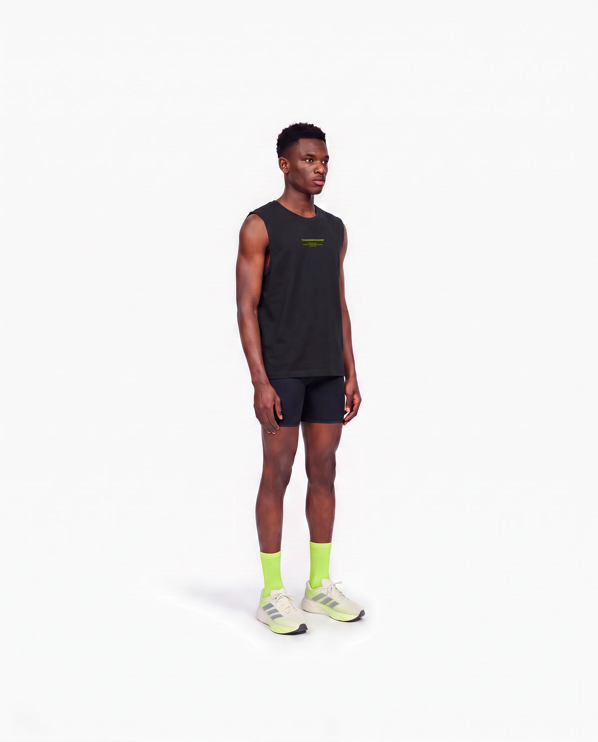Model wearing the Brick by Brick tank top in black — three-quarter view showing the regular fit — Vista 3