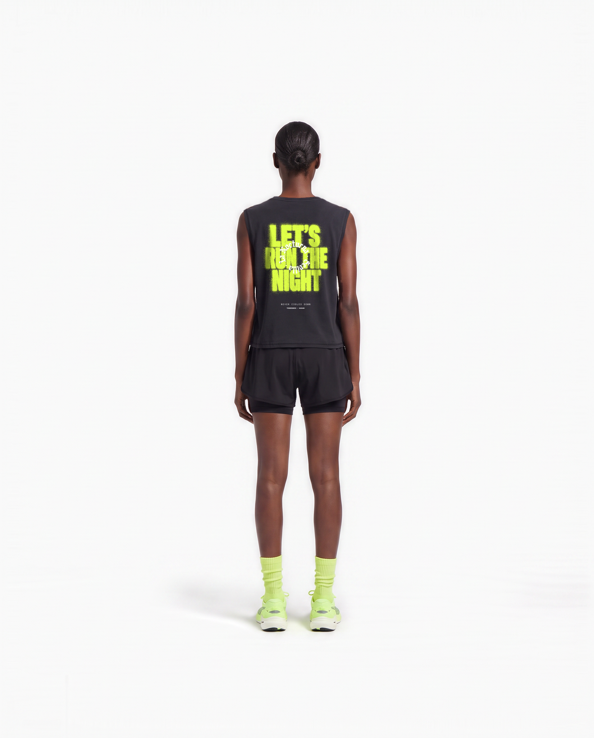 Model wearing the Let's Run the Night cropped tank top in black — back view with LET'S RUN THE NIGHT sprayed in electric lime around the La Nocturna Sevilla seal — Ansicht 6