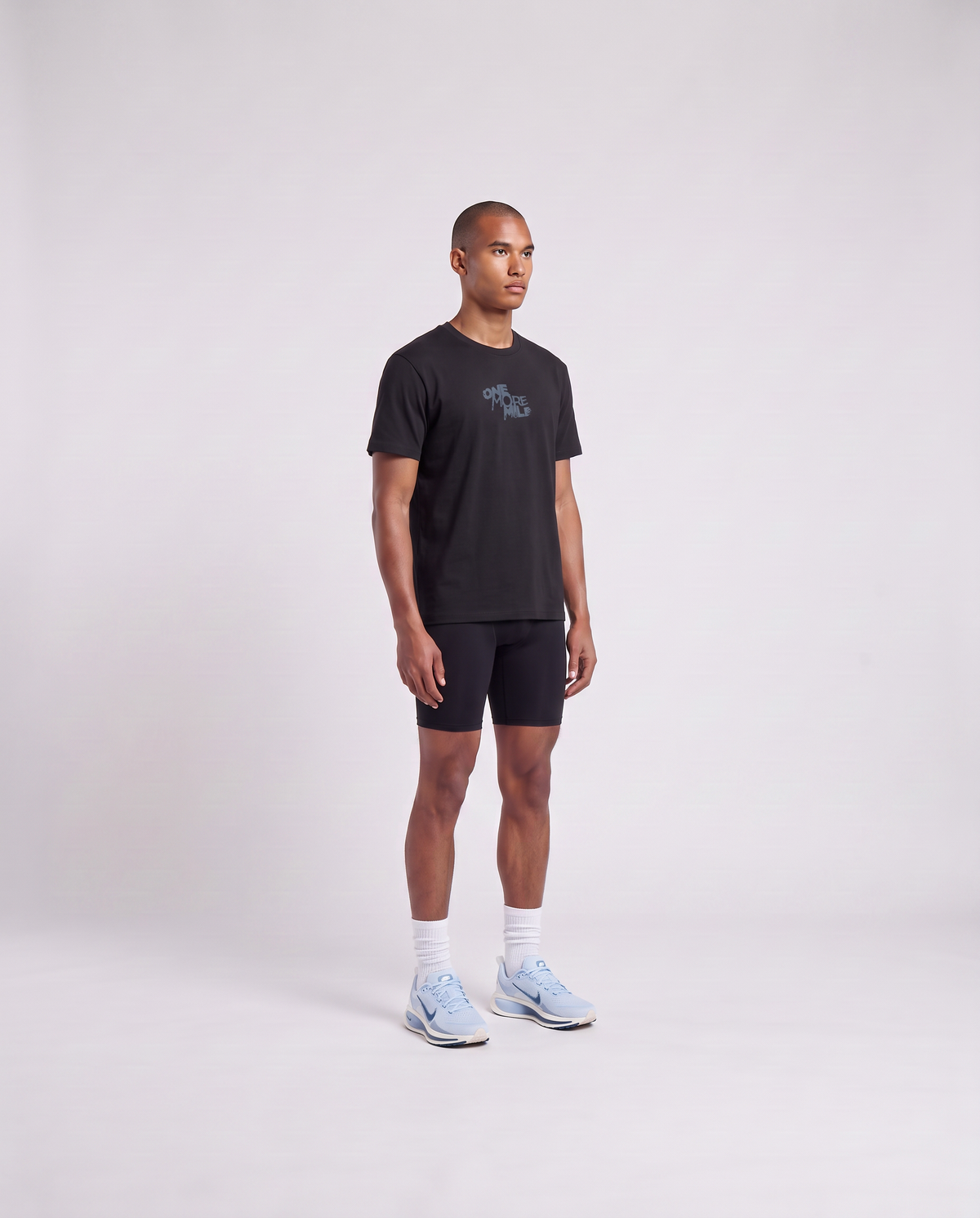 Model wearing the One More Mile t-shirt in black — three-quarter view showing the regular fit — Ansicht 3