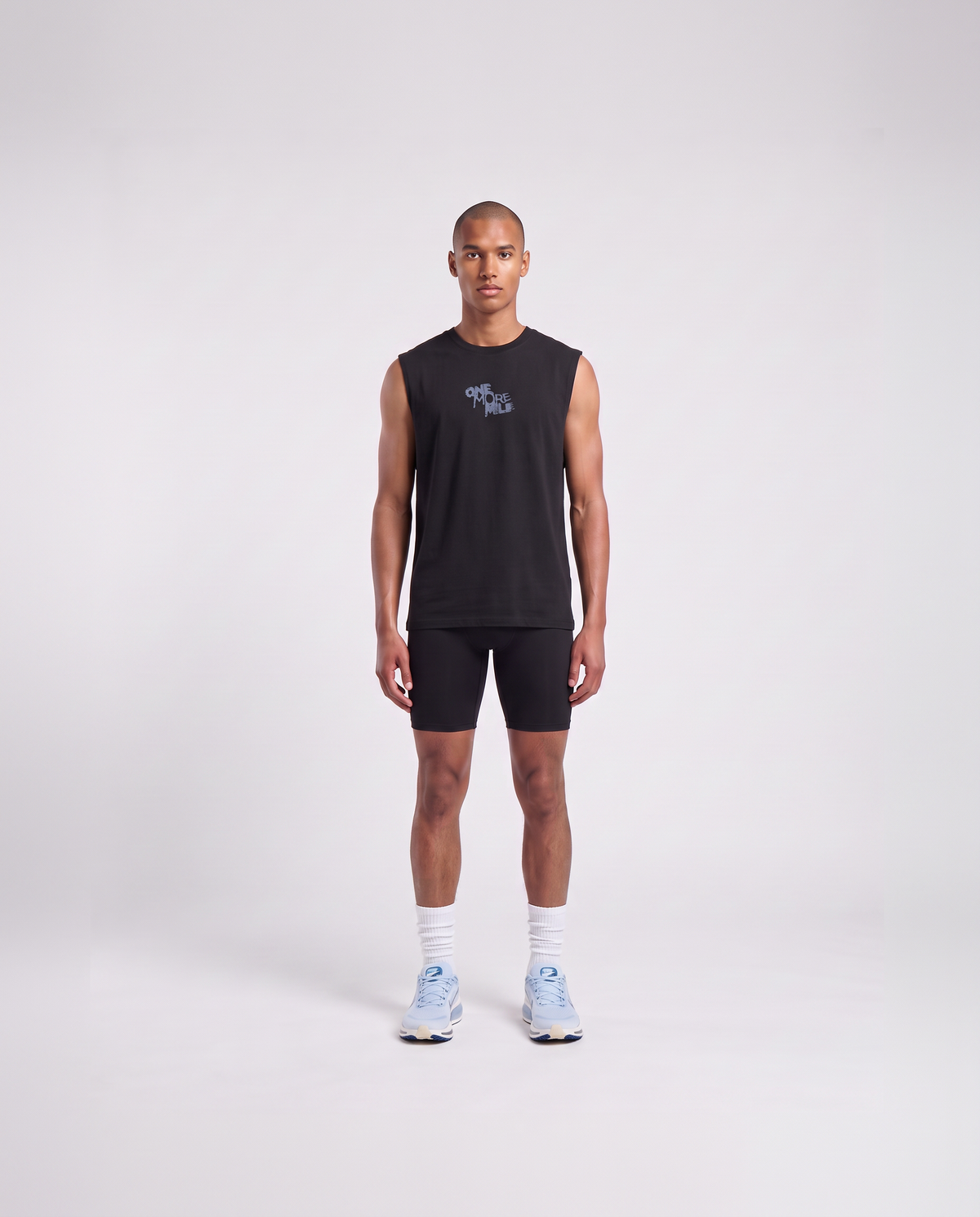 Model wearing the One More Mile tank top in black — front view with the ONE MORE MILE graffiti mark at the chest in slate blue — Ansicht 2
