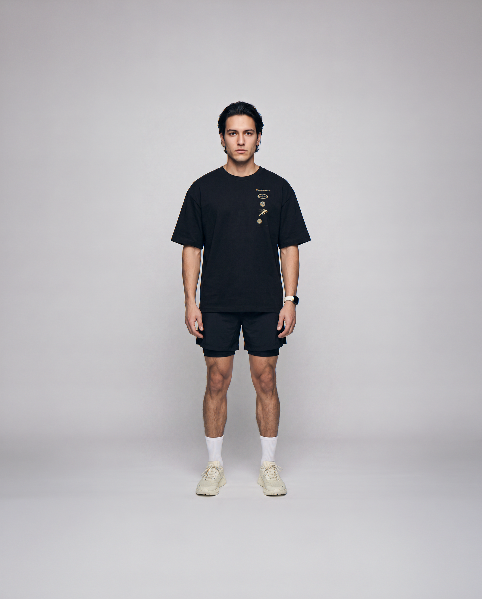 Model wearing the Strong Enough to Run oversize t-shirt in black — front view with the right-chest marker column in sand and grey — Ansicht 4