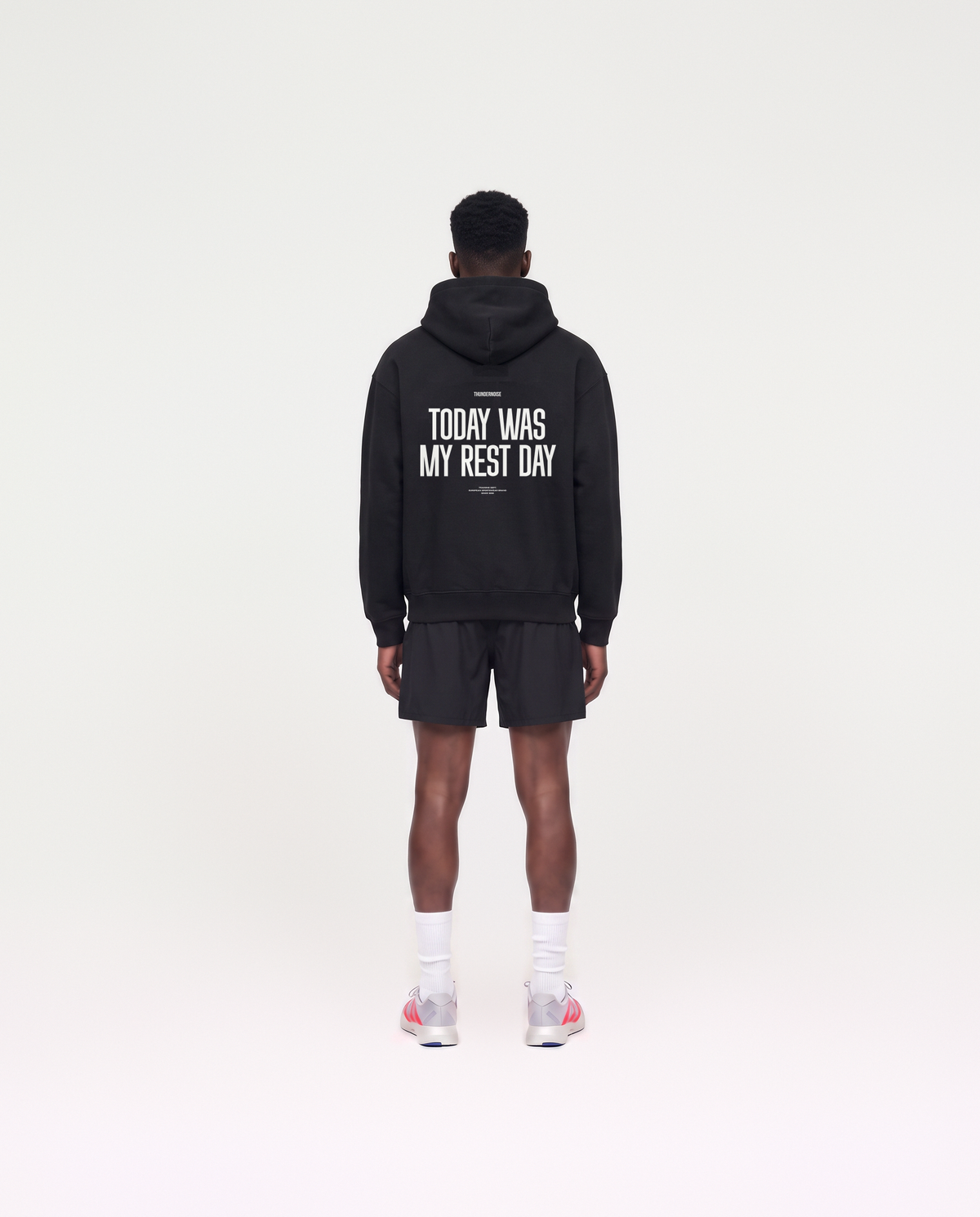 Model wearing the Today Was My Rest Day oversize hoodie in black — back view with the TODAY WAS MY REST DAY block in white — Vue 4