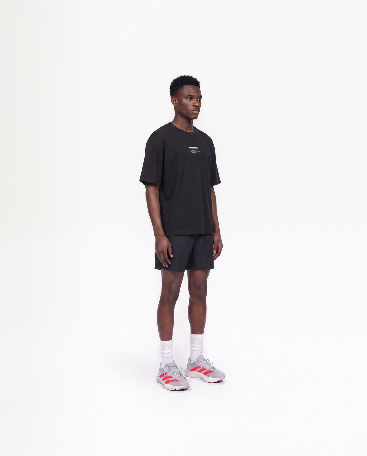 Model wearing the Today Was My Rest Day oversize t-shirt in black — three-quarter view showing the oversize fit — Vue 3