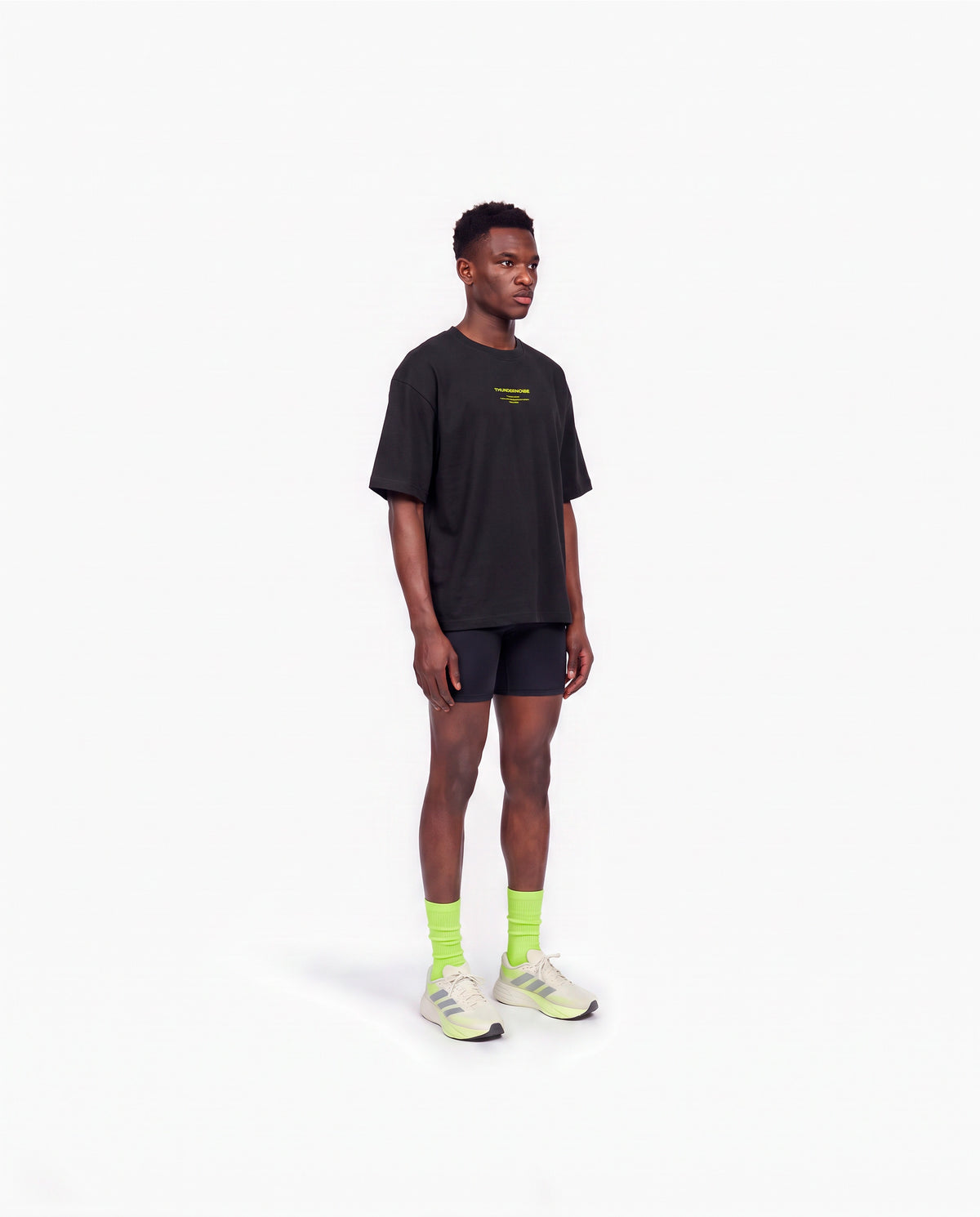 Model wearing the Brick by Brick oversize t-shirt in black — three-quarter view showing the oversize fit — Vista 3
