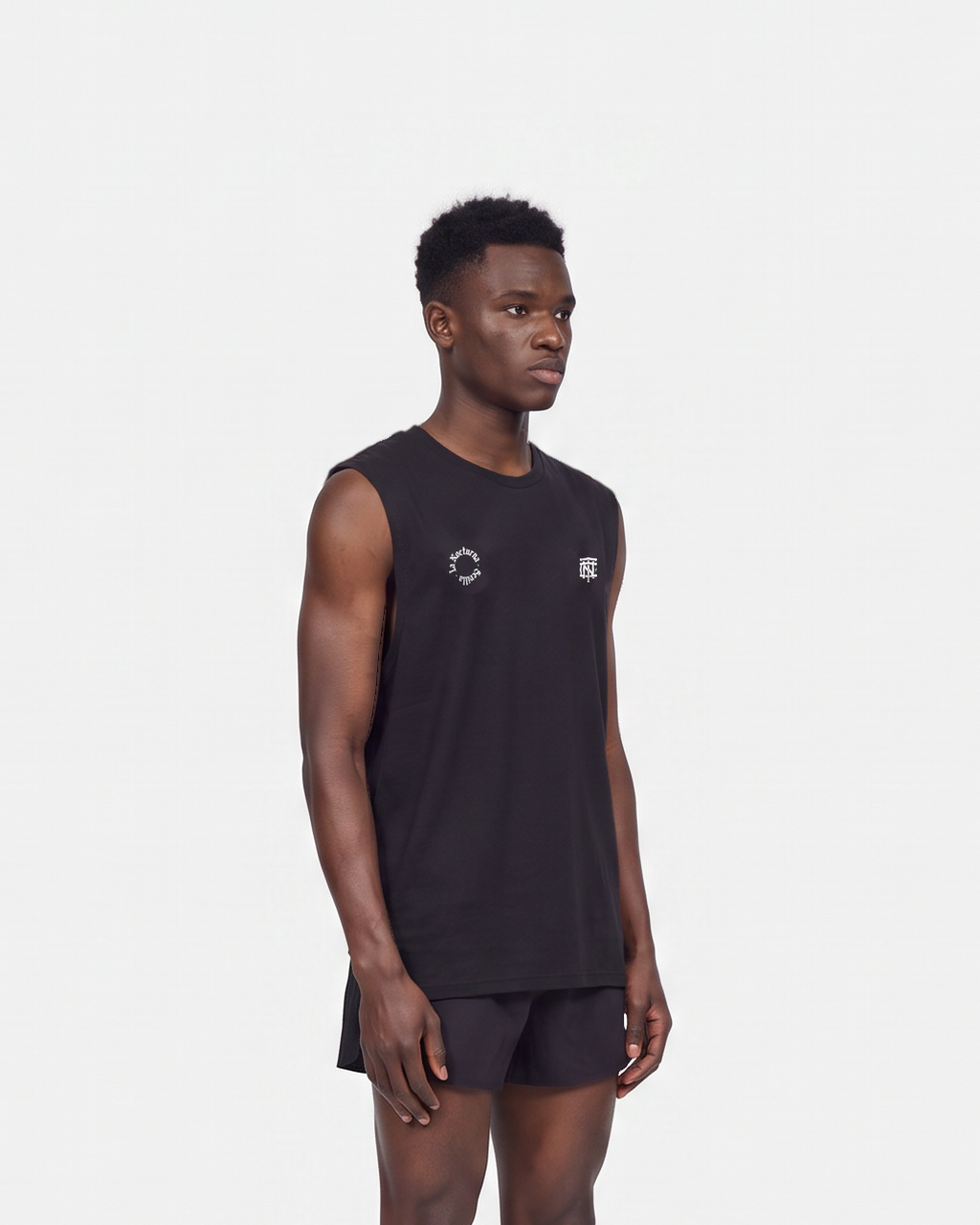 Model wearing the Let's Run the Night tank top in black — three-quarter view, close crop on the regular fit — Vista 5
