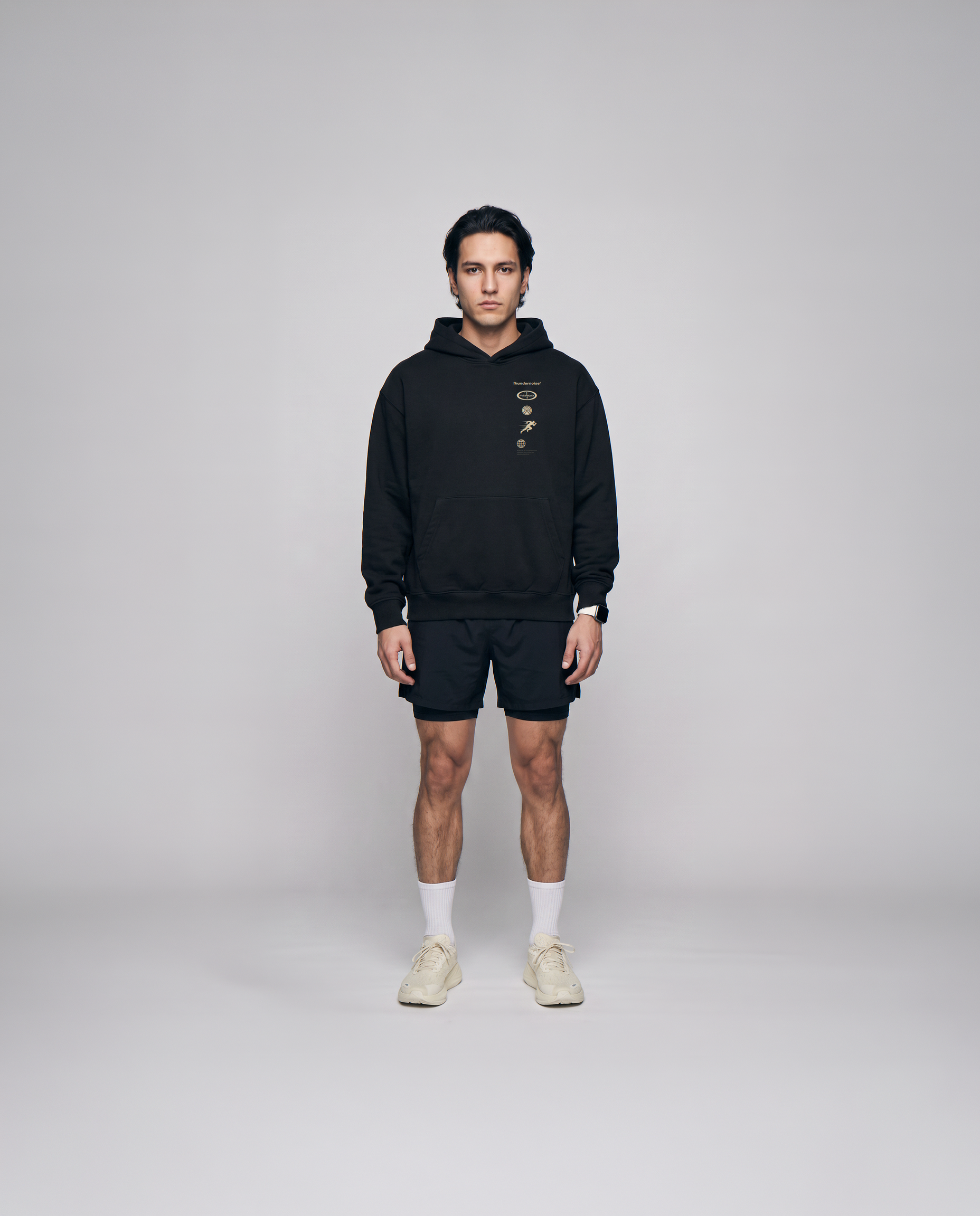Model wearing the Strong Enough to Run oversize hoodie in black — front view with the right-chest marker column in sand and grey