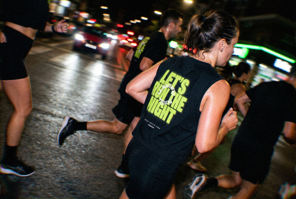 Night run in Sevilla wearing the black Let's Run the Night tank with its lime back print.