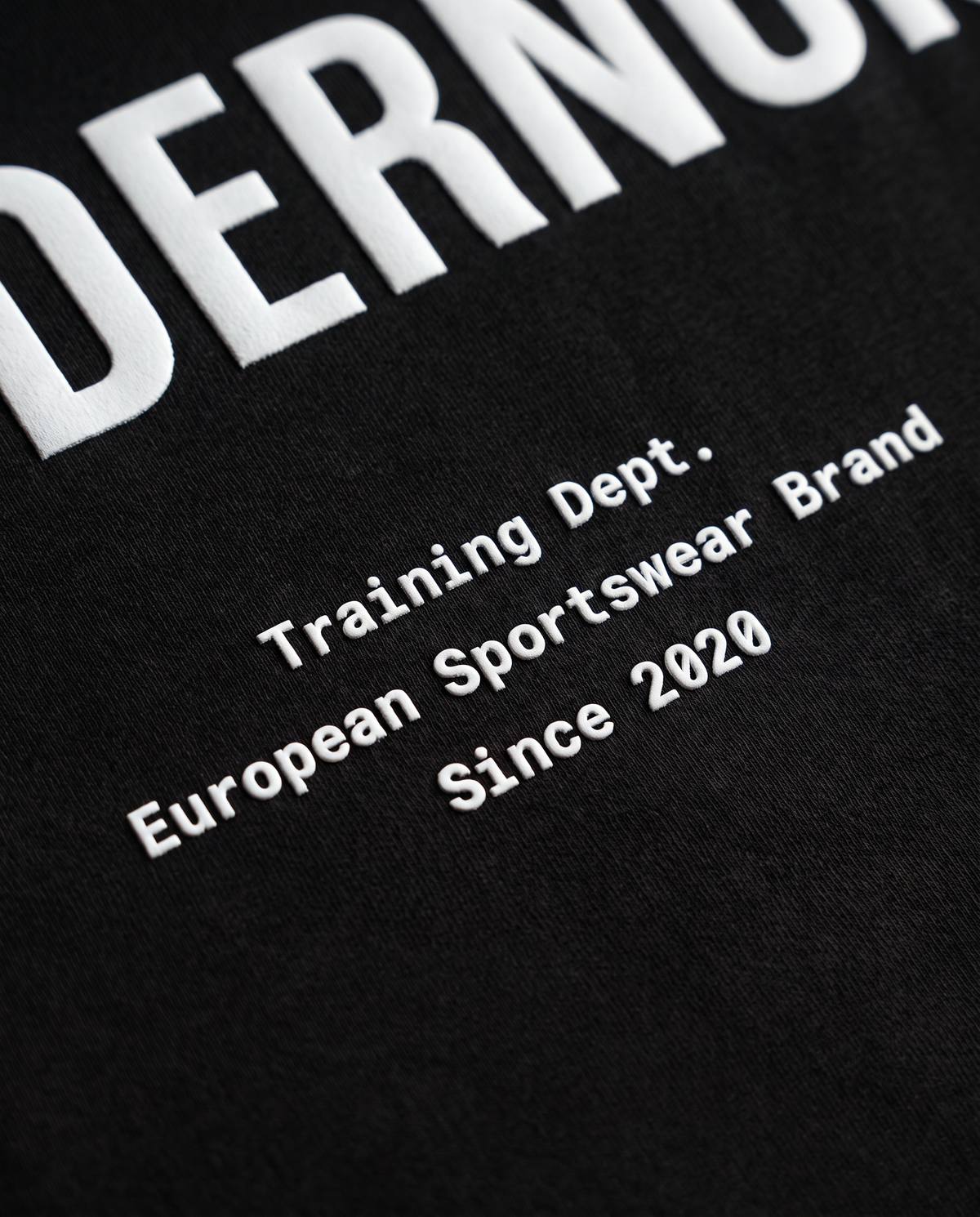 Training Dept. triblend cropped t-shirt in black — close-up of the raised high-density print on the back — Vista 5
